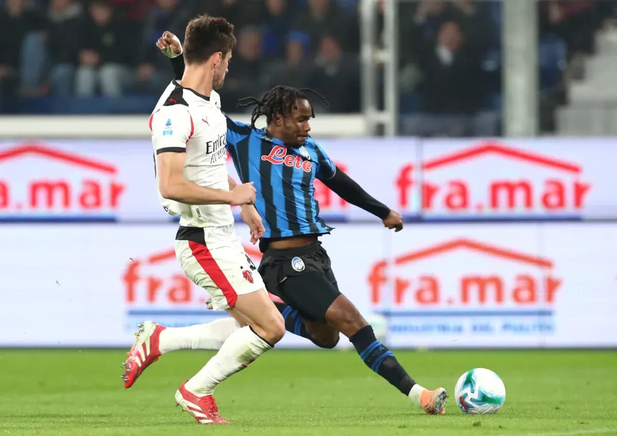 Jugador de Atalanta driblando a jugador de AC Milan