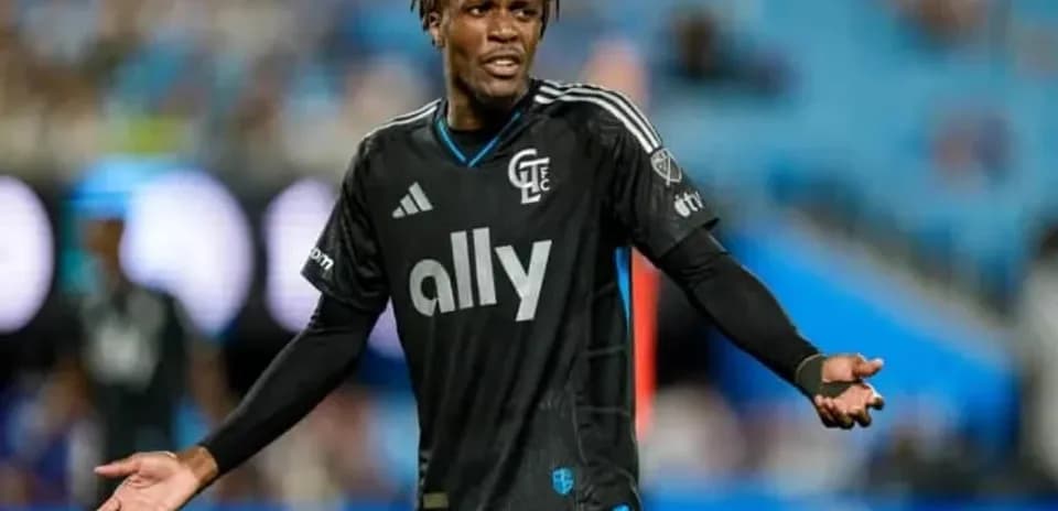 Jugador con camiseta negra gesticulando en el campo
