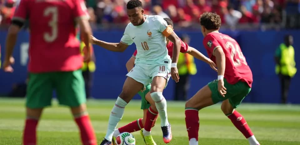 Jugador de Francia driblando a defensores de Marruecos