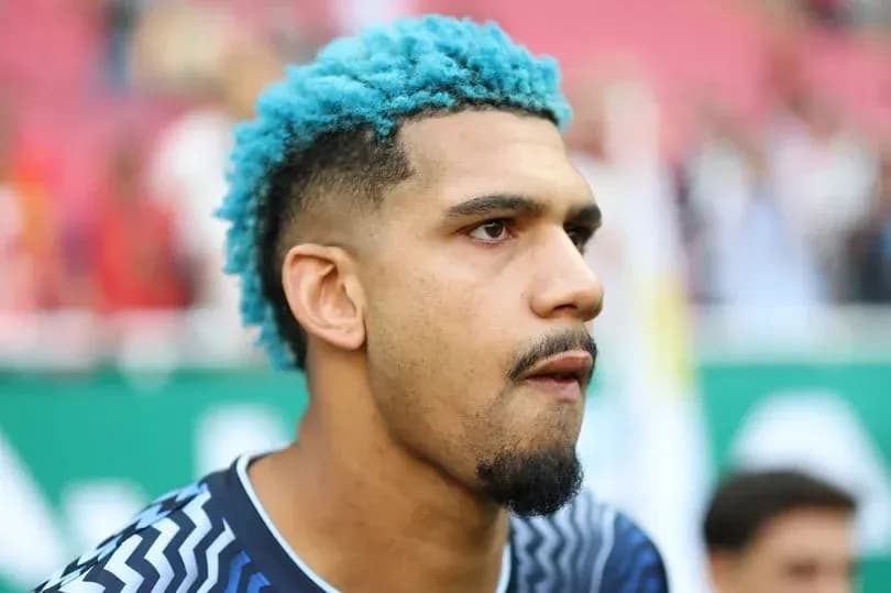 Jugador con cabello azul en el campo de fútbol