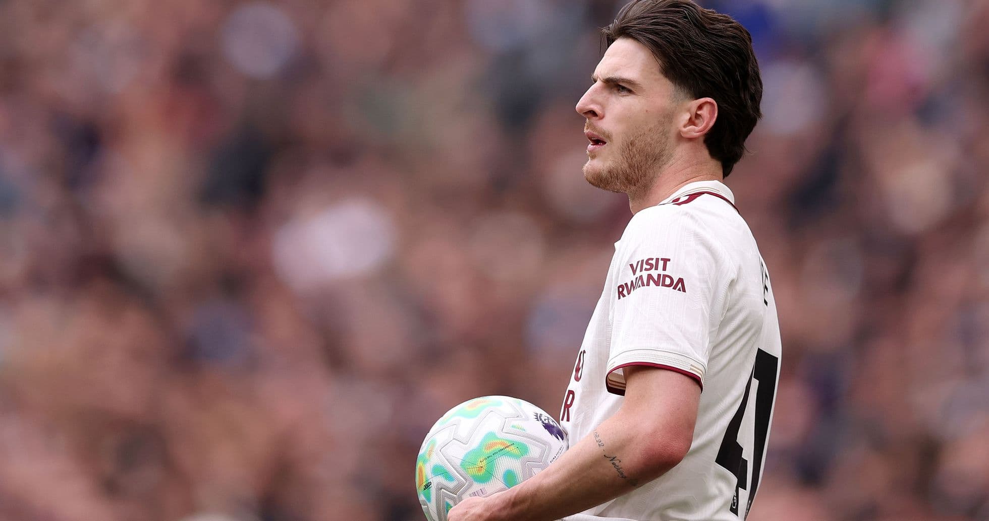 Jugador sosteniendo un balón en el campo