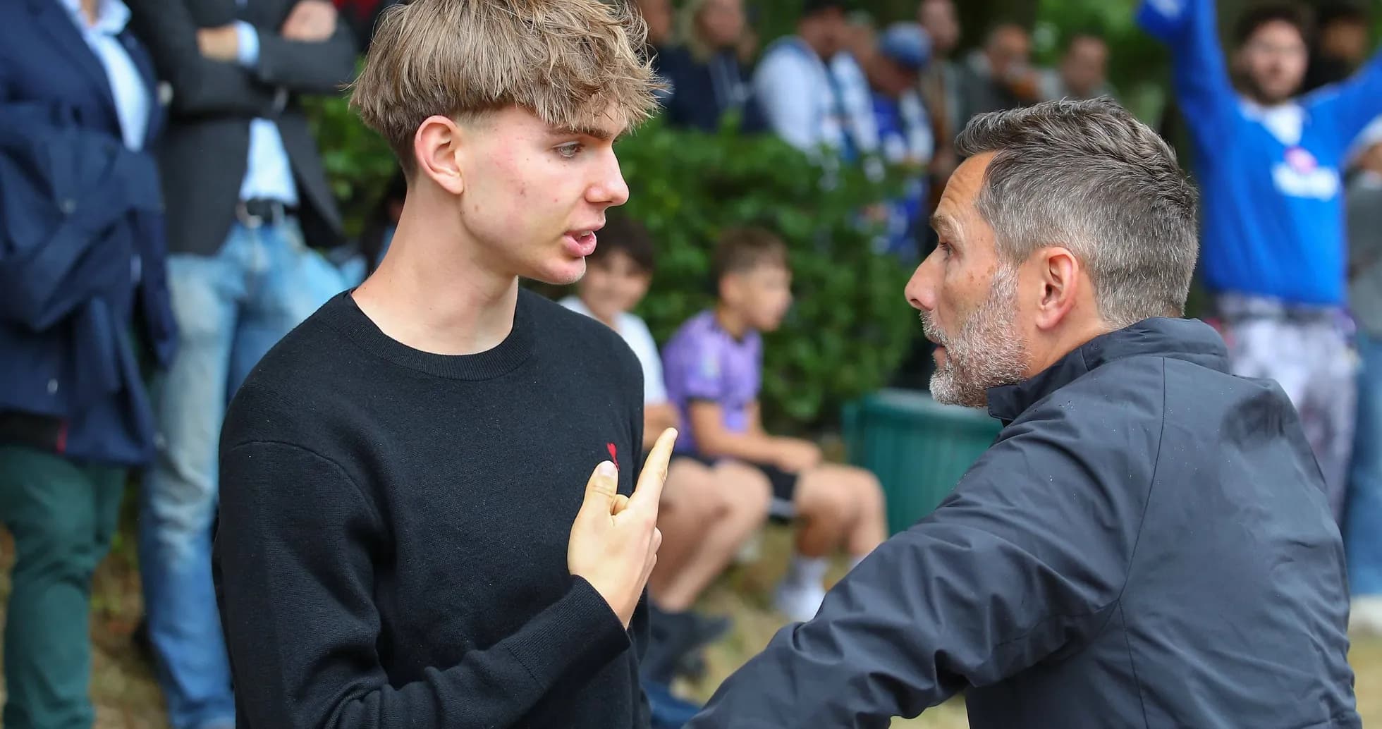 Joven discutiendo con un entrenador en el campo