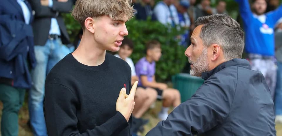 Joven discutiendo con un entrenador en el campo