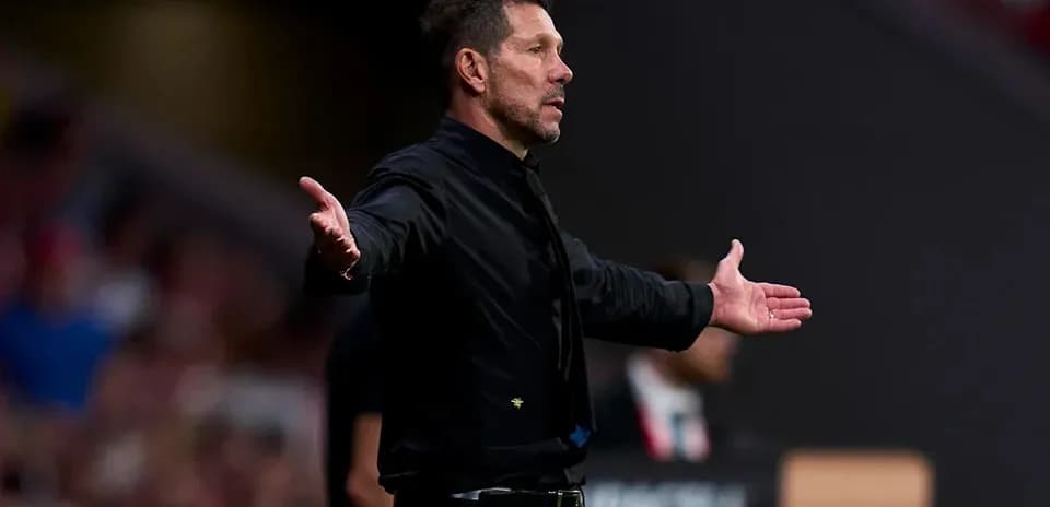 Entrenador gesticulando en la banda del campo