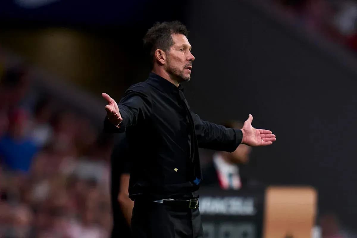 Entrenador gesticulando en la banda del campo