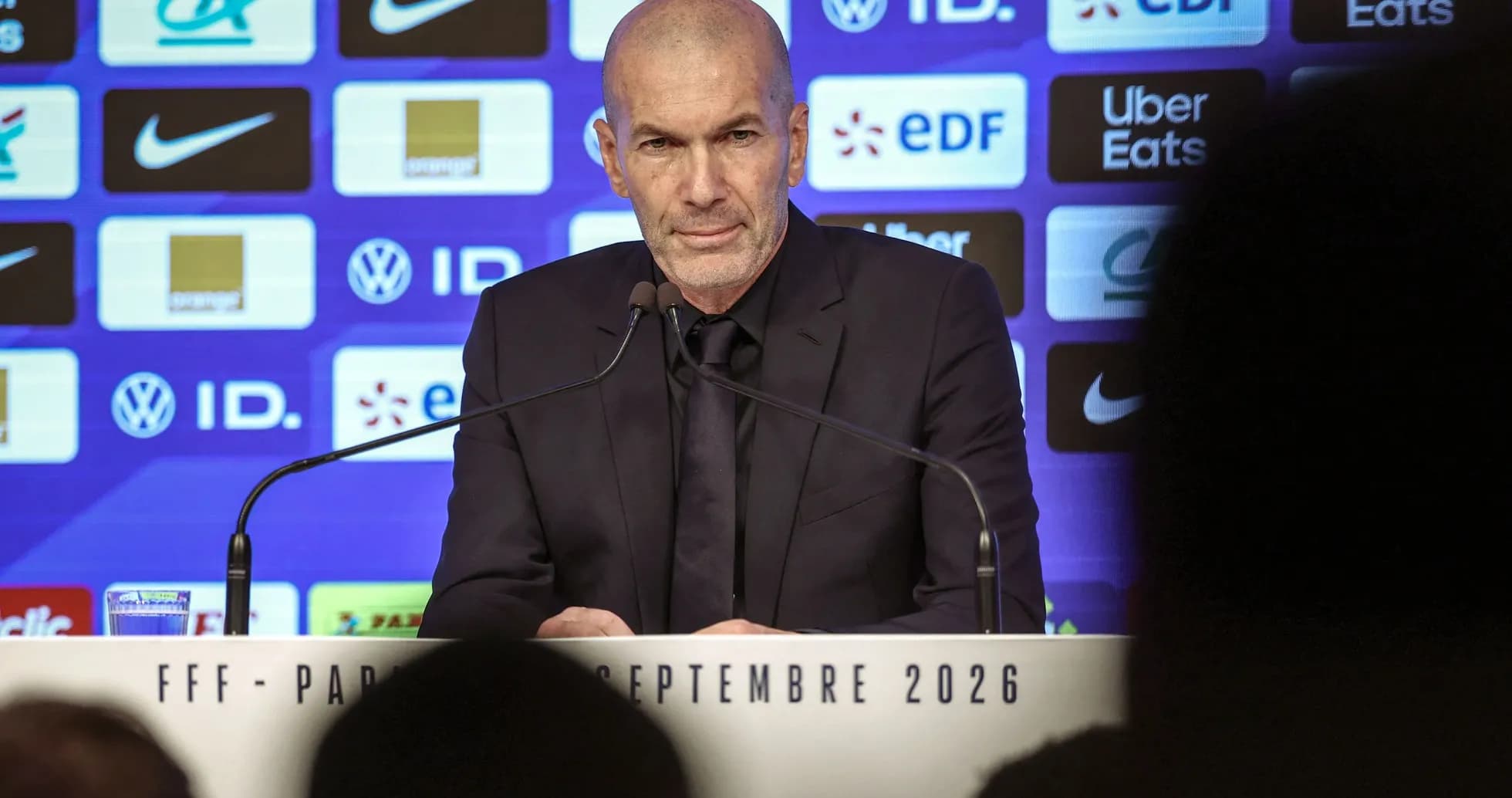 Entrenador en conferencia de prensa con micrófonos