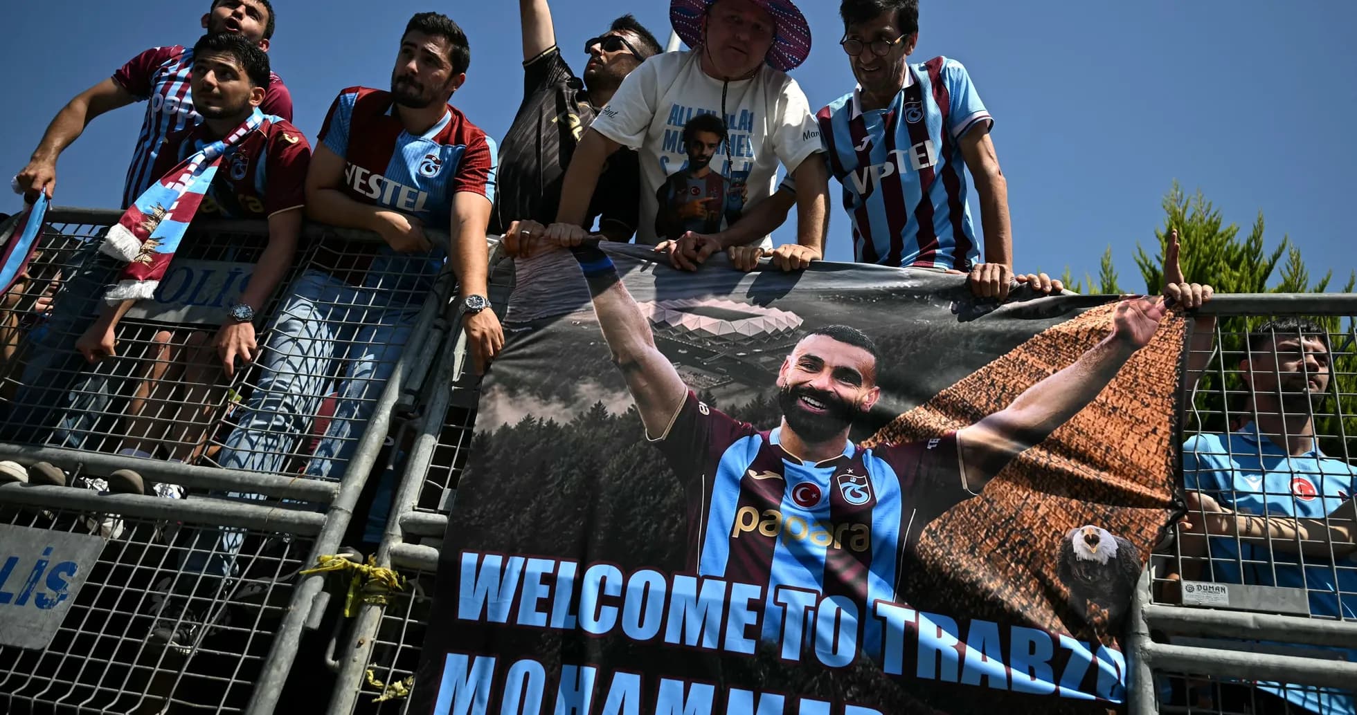 Aficionados sosteniendo un banner de bienvenida en Trabzon