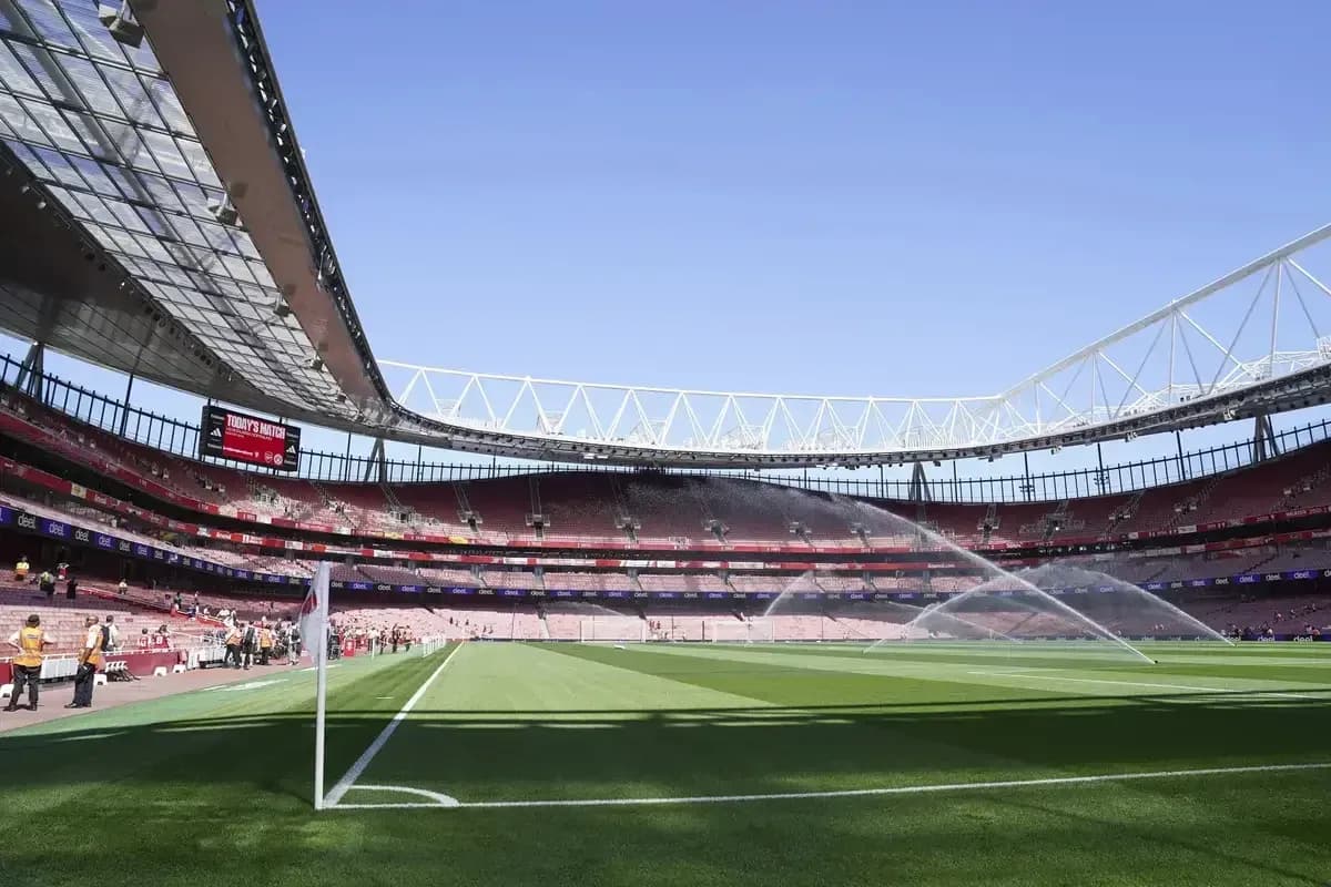 Estadio con césped regado y asientos vacíos