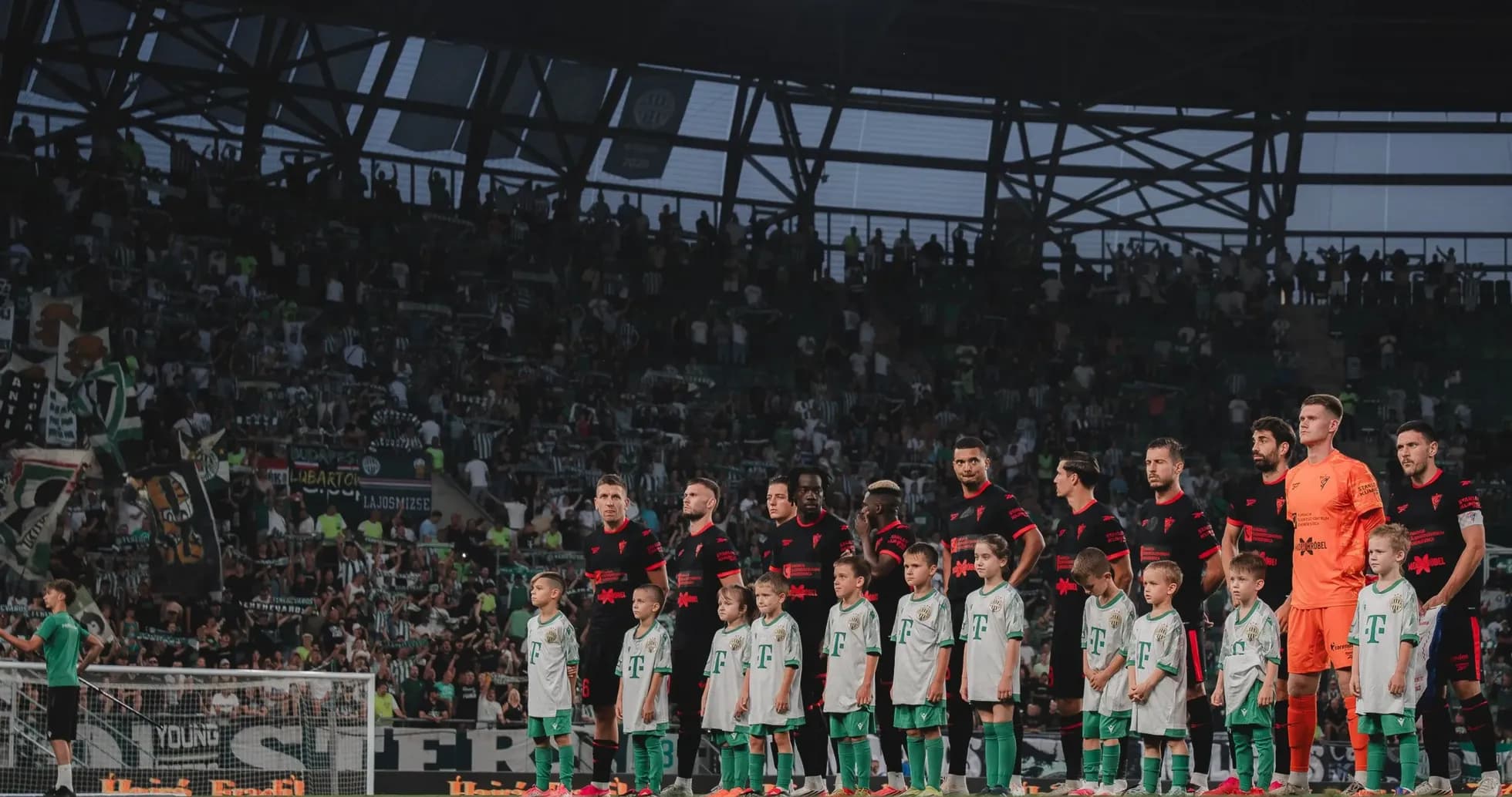 Jugadores de Ferencvarosi y niños en el campo