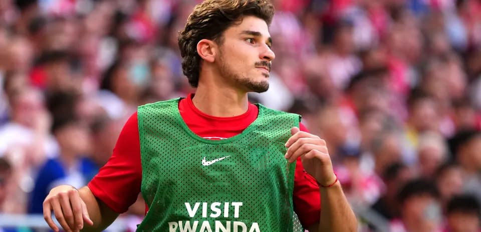 Jugador calentando con chaleco en el campo