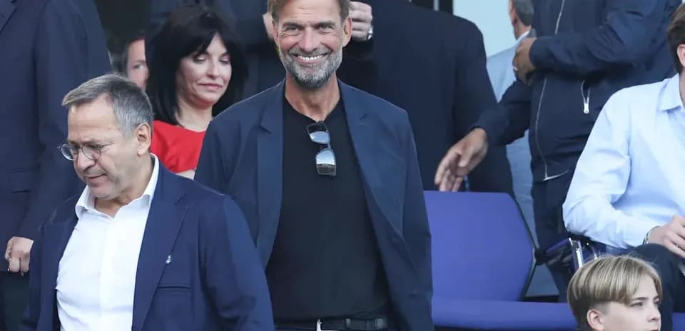 Entrenador sonriendo en evento con otras personas