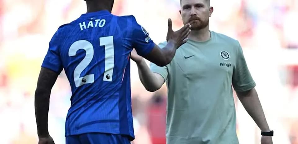 Jugador de Chelsea saludando al entrenador en el campo