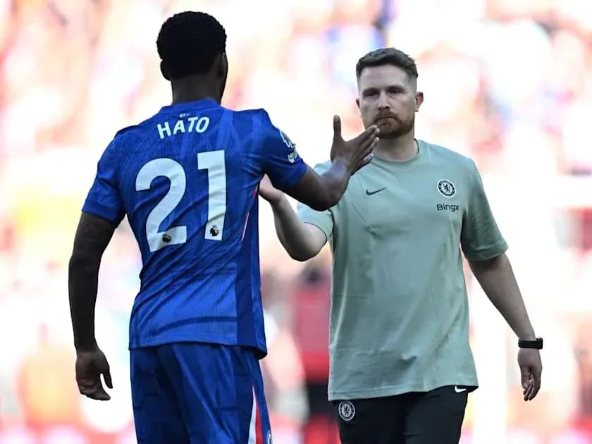 Jugador de Chelsea saludando al entrenador en el campo