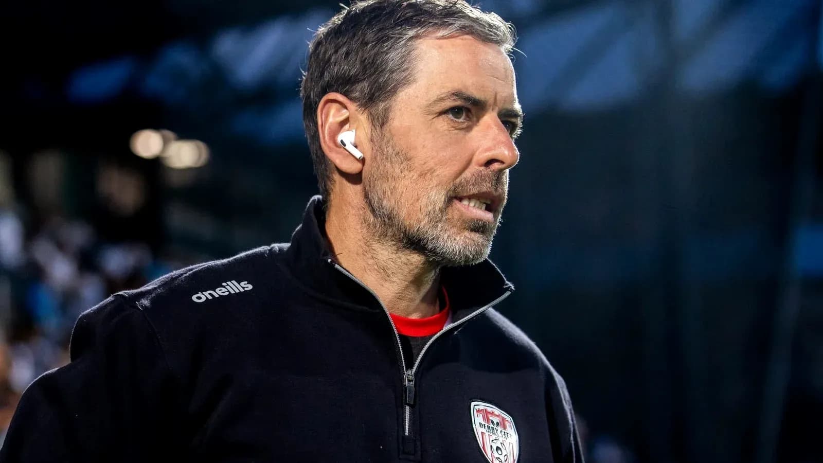 Entrenador de Derby City con auriculares en el campo