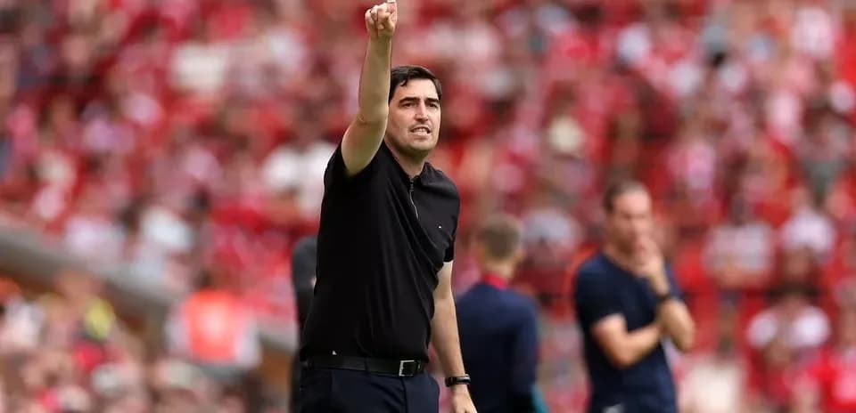 Entrenador señalando instrucciones desde la línea de banda
