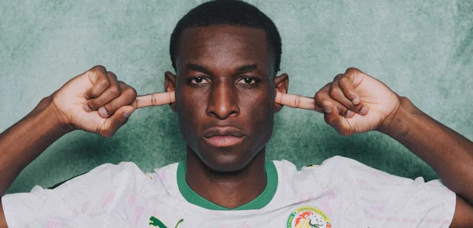 Jugador senegalés cubriendo sus oídos con las manos