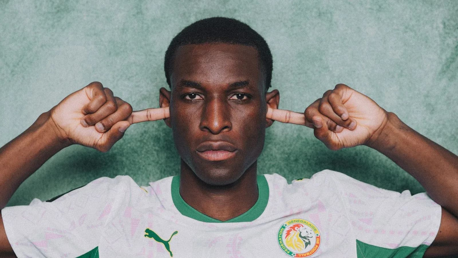 Jugador senegalés cubriendo sus oídos con las manos