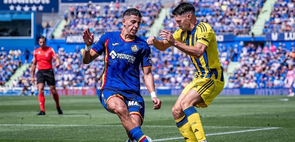 Jugadores de Getafe y Oviedo compitiendo por el balón