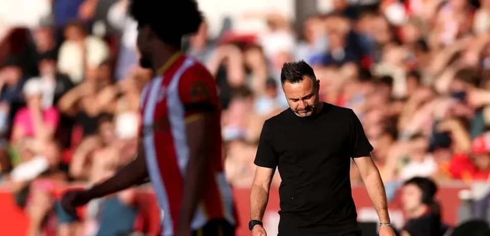 Entrenador caminando con cabeza baja durante el partido
