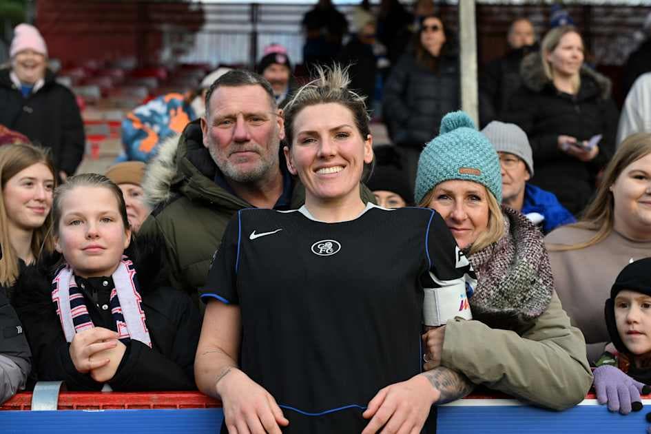 Jugadora sonriendo con aficionados en el fondo