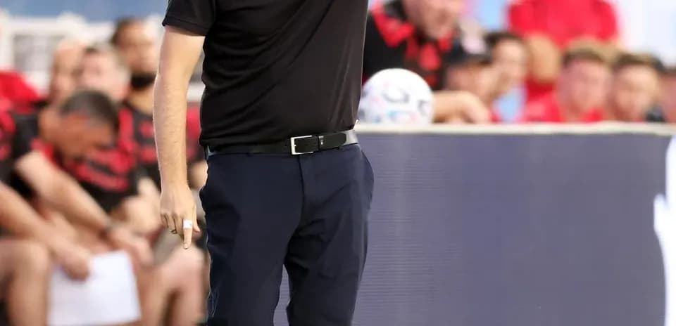 Entrenador dirigiendo al equipo desde la línea de banda