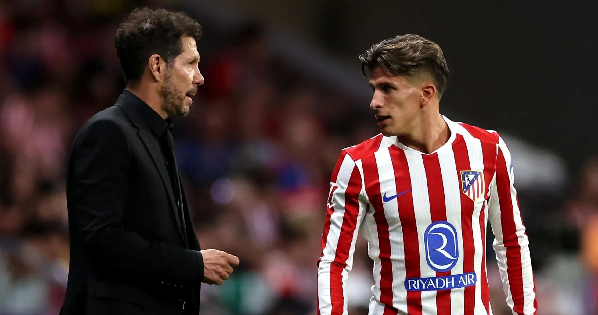 Entrenador hablando con jugador de Atlético de Madrid