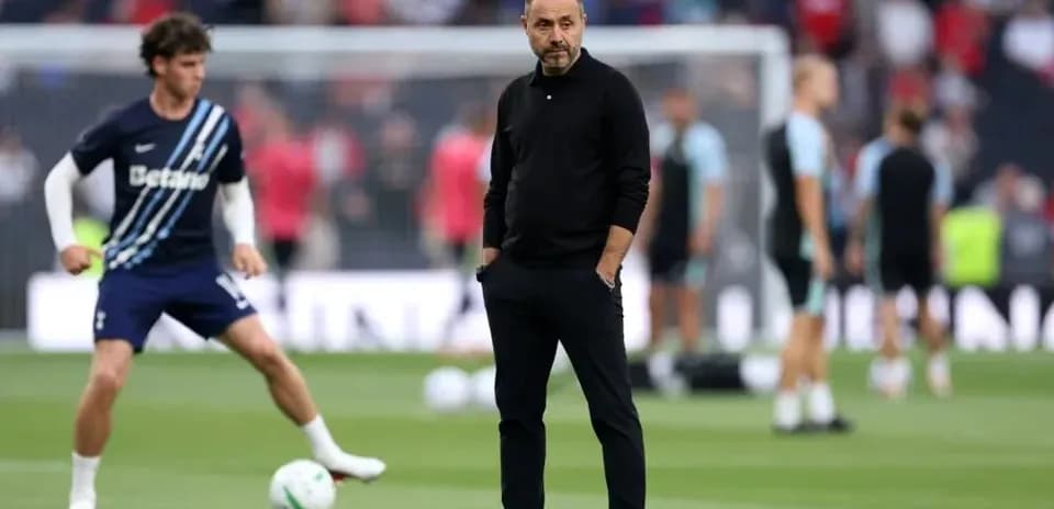 Entrenador observando calentamiento de jugadores en el campo