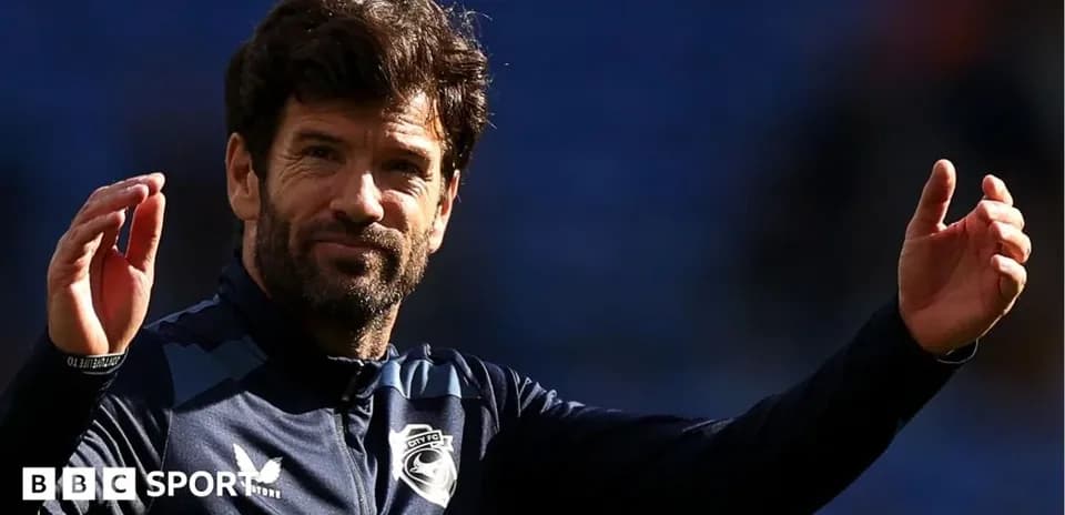Entrenador saludando al público en el estadio