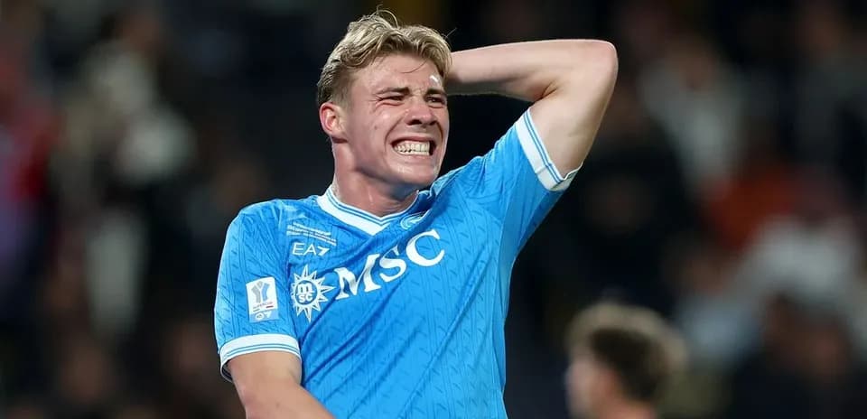 Jugador de fútbol con camiseta azul mostrando frustración
