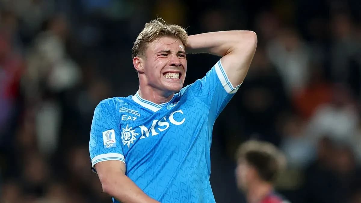 Jugador de fútbol con camiseta azul mostrando frustración