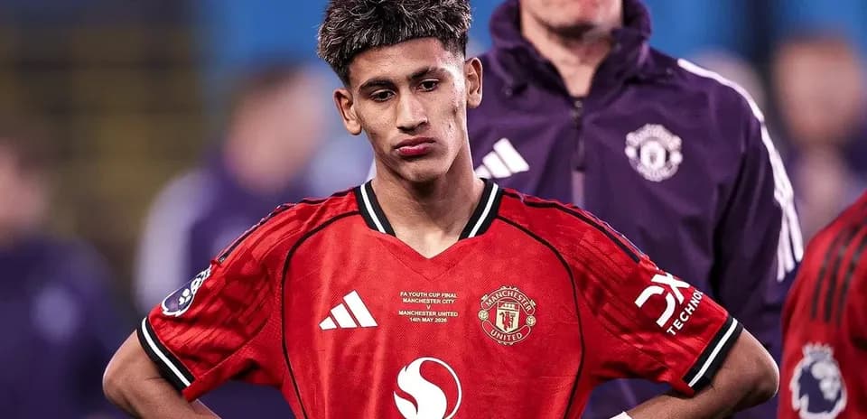 Jugador de Manchester United con camiseta roja, mirando hacia abajo