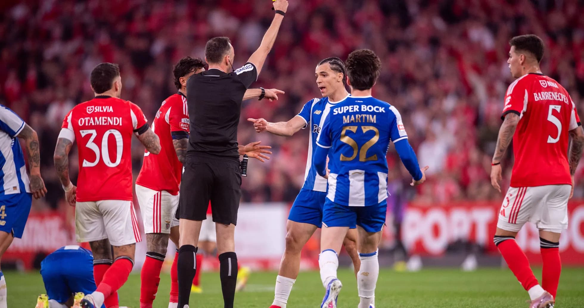 Árbitro mostrando tarjeta amarilla a jugador en partido