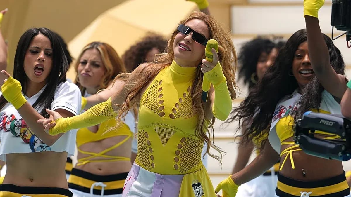 Artista en actuación con bailarinas en trajes coloridos