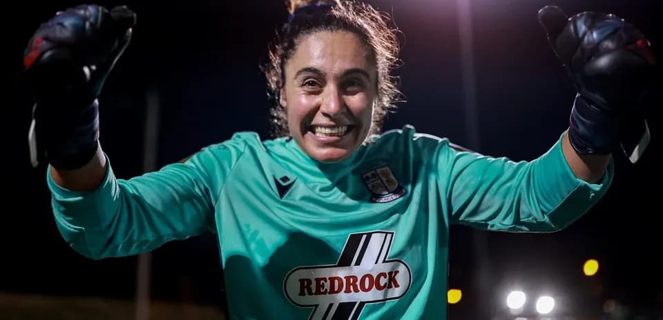 Portera sonriente levantando el puño en celebración