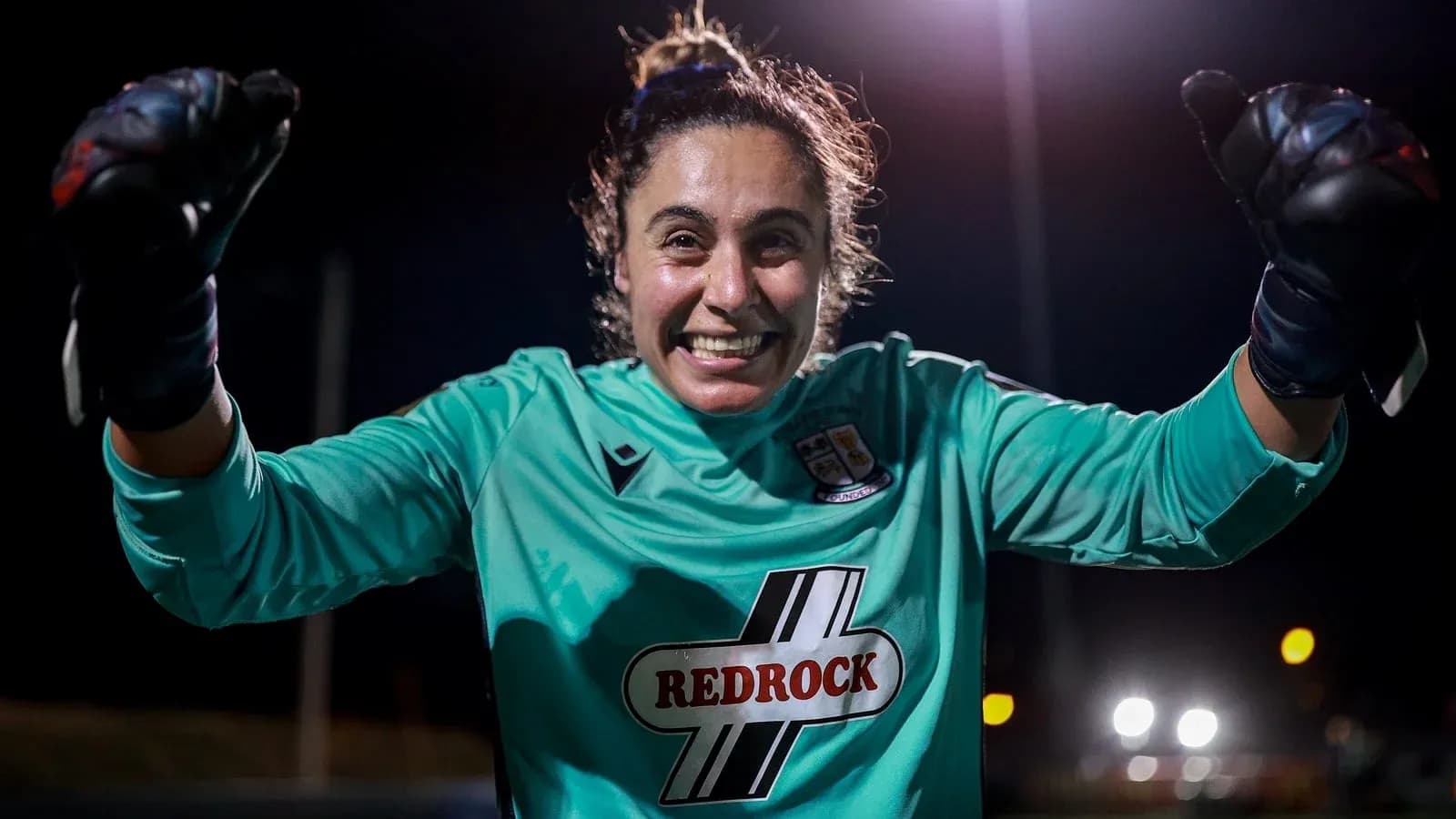 Portera sonriente levantando el puño en celebración
