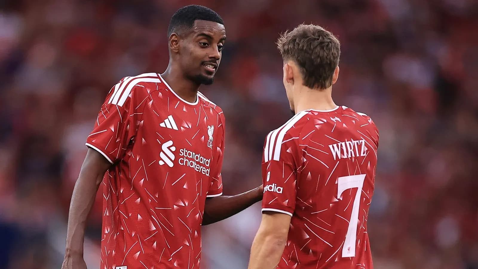 Jugadores de Liverpool conversando en el campo