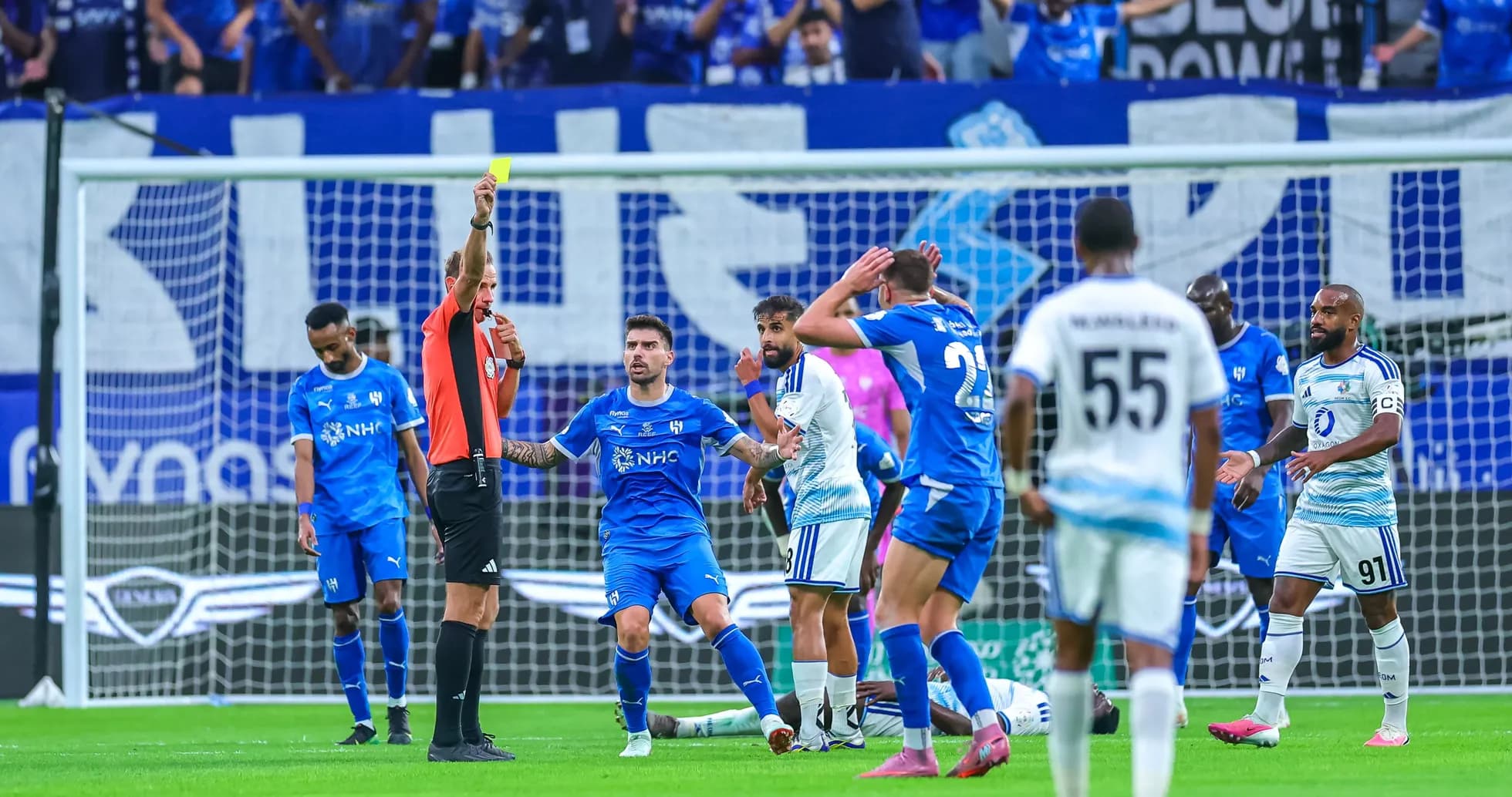 Árbitro mostrando tarjeta amarilla en partido de fútbol