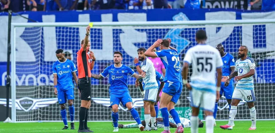 Árbitro mostrando tarjeta amarilla en partido de fútbol