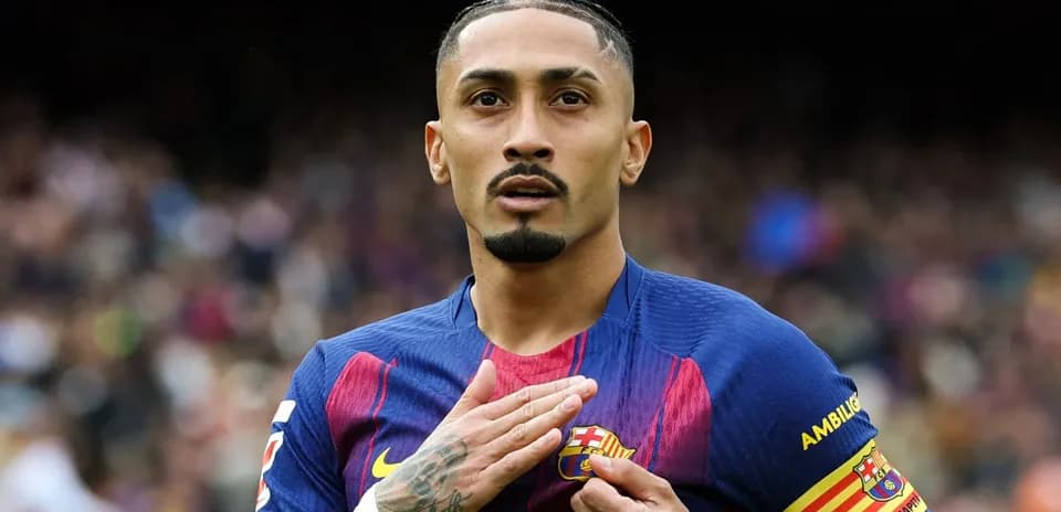 Jugador de Barça tocando el escudo del equipo