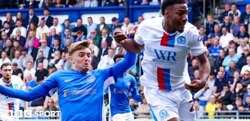 Jugador de camiseta blanca siendo sujetado por rival