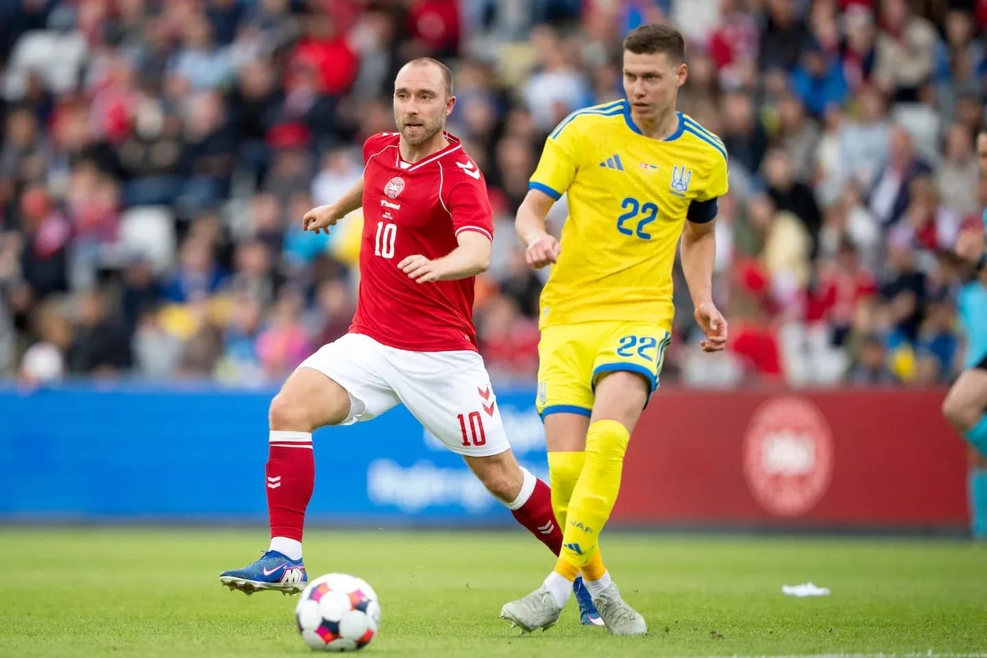Cristian Eriksen y jugador ucraniano corriendo tras balón