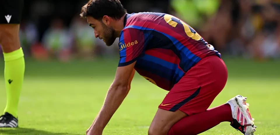 Jugador de Barcelona arrodillado en el campo de juego