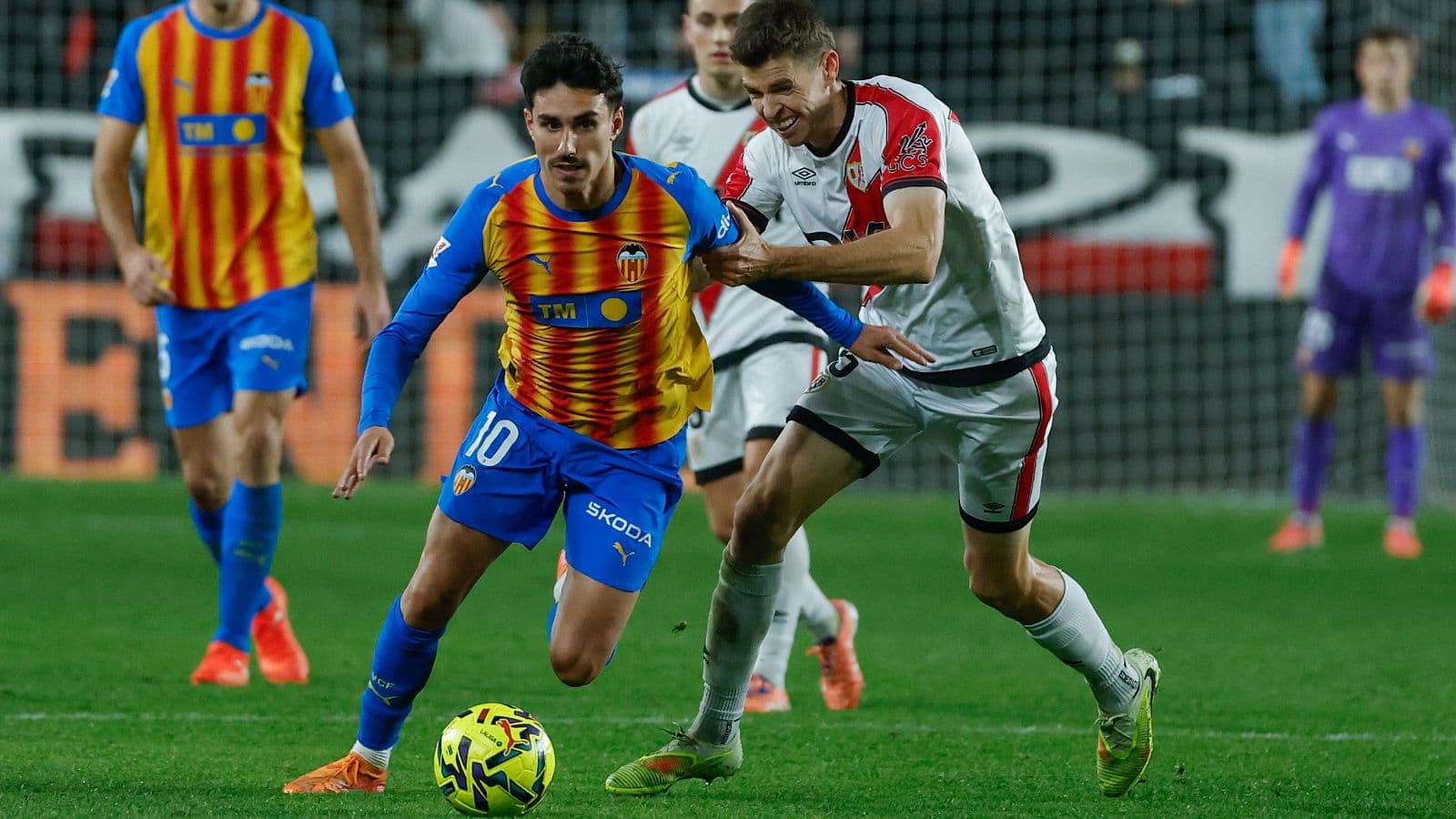 Jugador de Valencia driblando a un rival de Rayo Vallecano