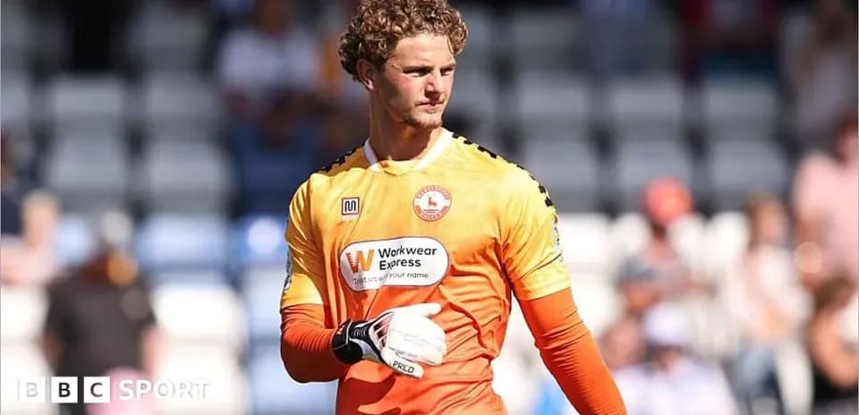 Portero con guantes en uniforme naranja durante el partido