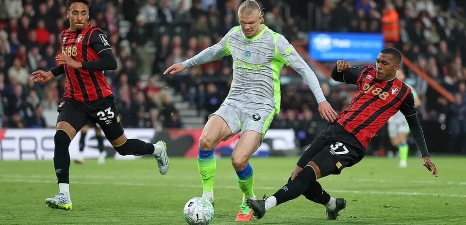 Haaland driblando entre dos defensores de Bournemouth