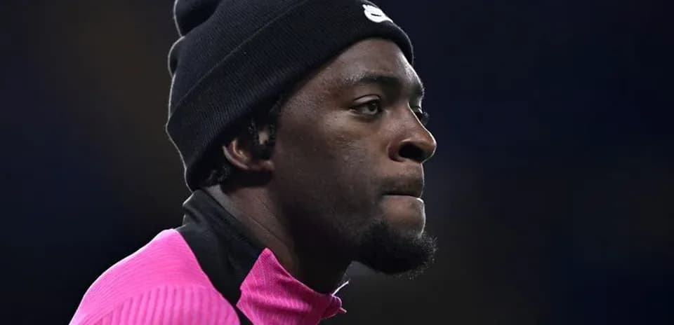 Jugador con gorro negro y camiseta rosa en el campo