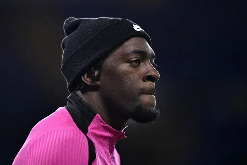 Jugador con gorro negro y camiseta rosa en el campo
