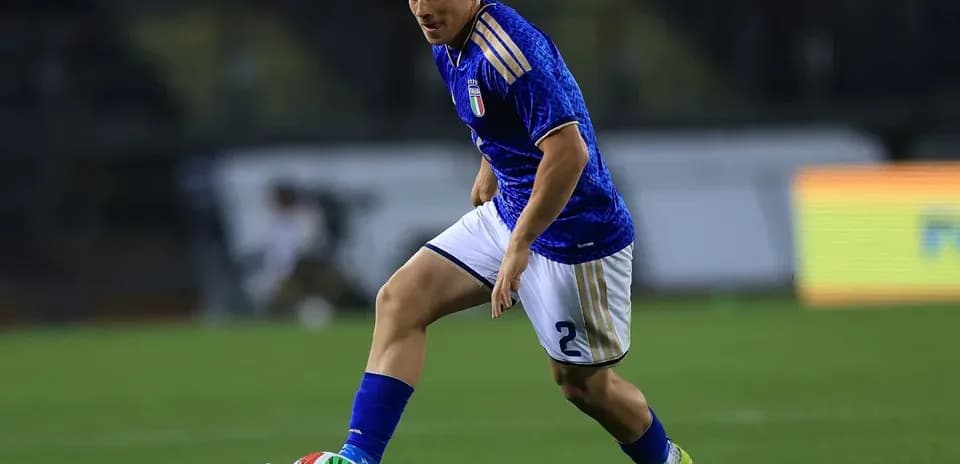 Jugador de Italia corriendo con el balón en campo