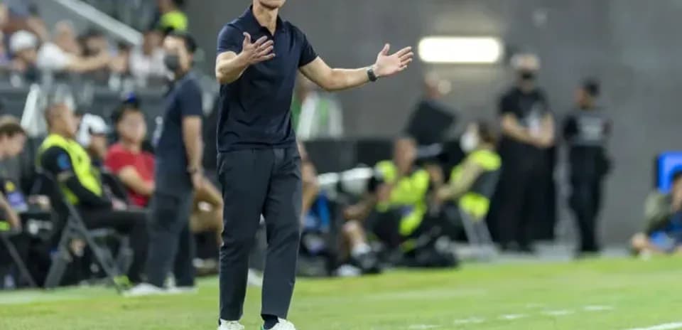 Entrenador gesticulando durante el partido en la línea lateral