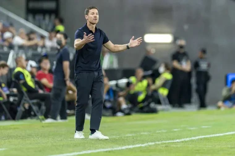 Entrenador gesticulando durante el partido en la línea lateral